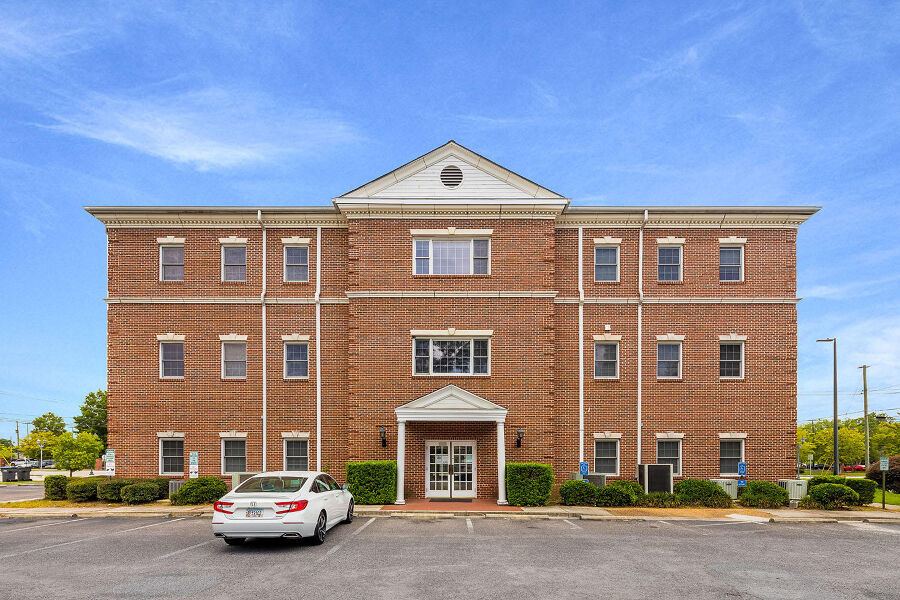 Three-story brick office building at 925 Laney Walker Blvd with surface parking